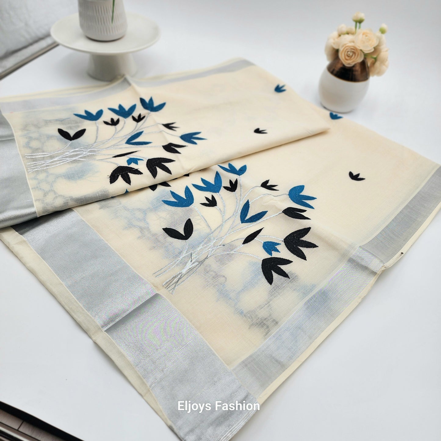 Tissue Silk Saree featuring Silver, Blue and Black floral design with Silver border.