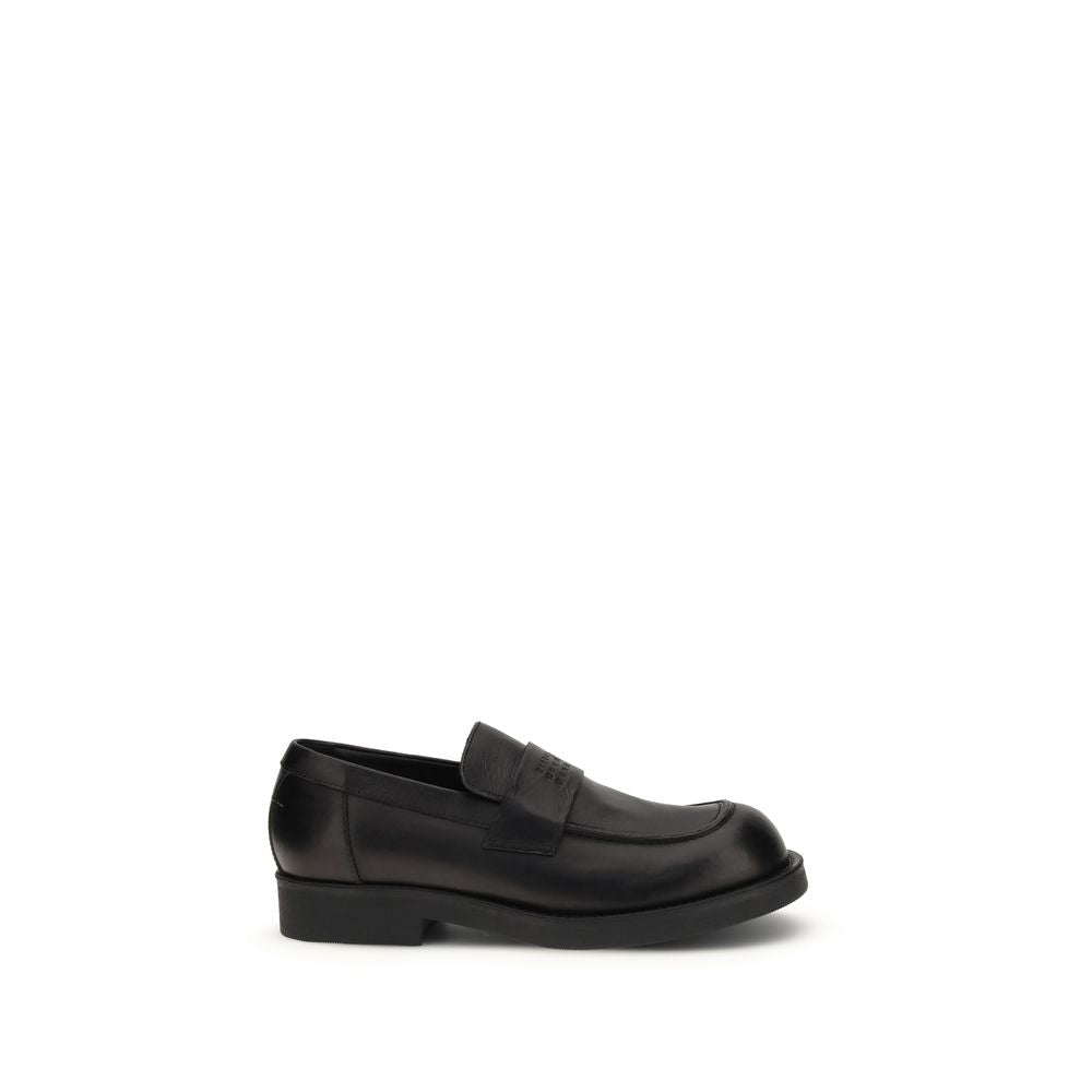 MM6 black calf leather Bos Taurus slip-on loafers showing sleek design and smooth leather finish.