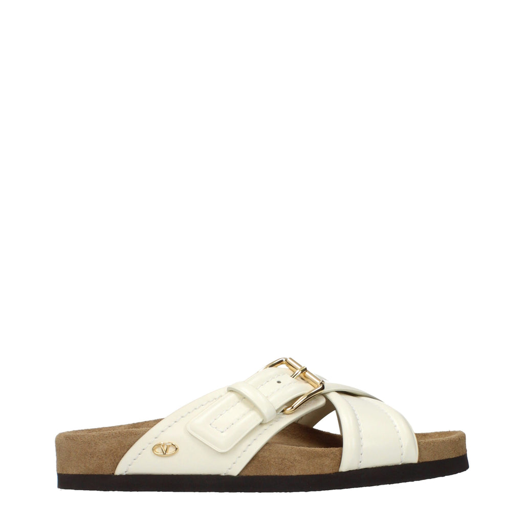 Valentino Garavani beige leather slippers with slip-on design and subtle branding, perfect for casual and stylish wear.