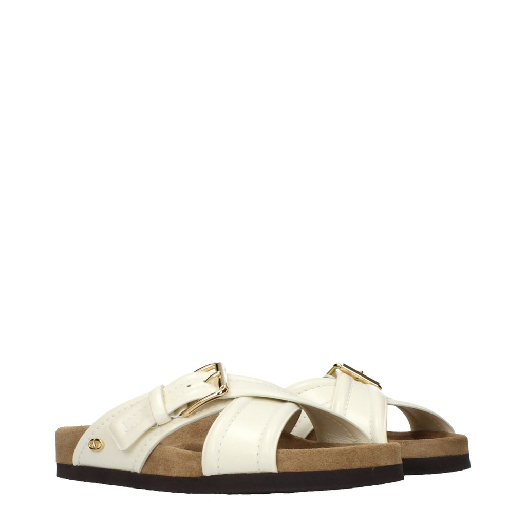 Beige leather slippers by Valentino Garavani featuring a sleek, minimalist design and comfortable slip-on style.