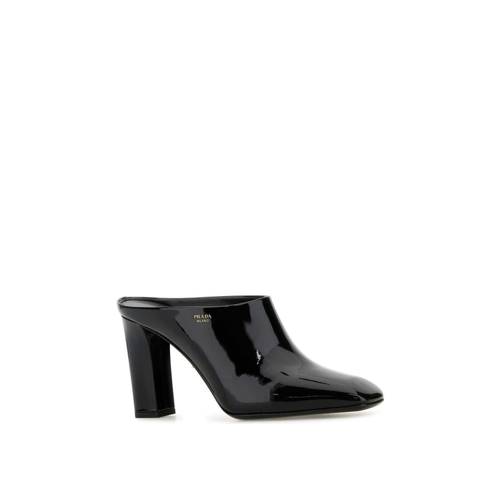 Prada black calfskin mules with pointed toes and sleek design, showcasing elegant slip-on footwear for women.