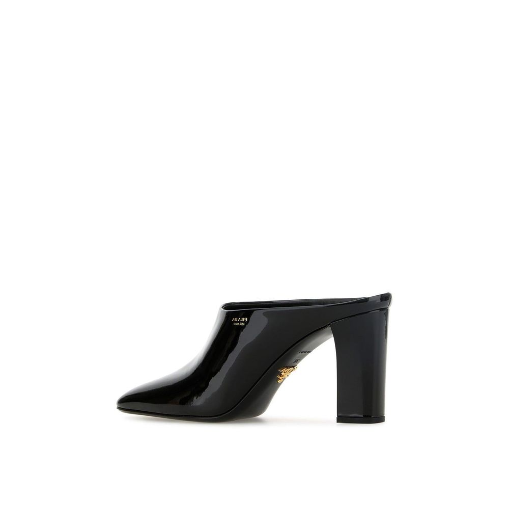 Prada black calfskin mules with pointed toes and slip-on design, showcasing sleek, stylish footwear for women.