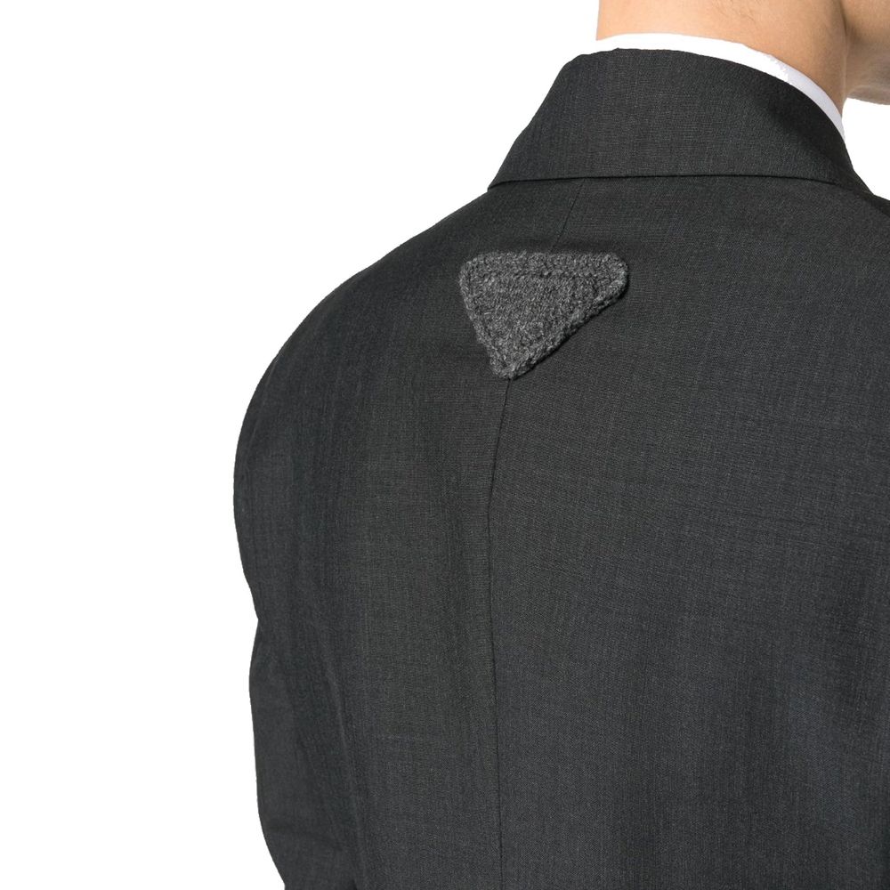 Prada gray wool blazer with tailored fit and classic lapel, displayed on a hanger against a neutral background.