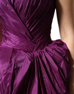 Dolce & Gabbana purple strapless A-line asymmetric dress displayed on a hanger, showcasing its elegant design and vibrant color.