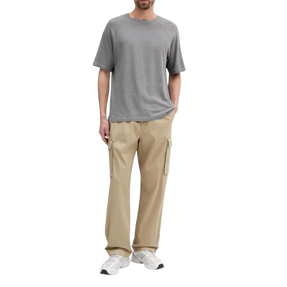 Beige cotton cargo pants by Calvin Klein Jeans showing relaxed fit and multiple utility pockets on the front and sides.