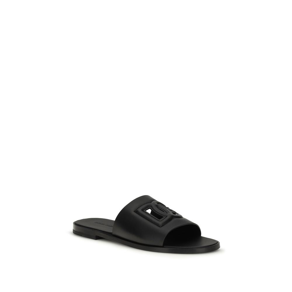 Dolce & Gabbana black calf leather Bos Taurus sandals with open-toe design and ankle strap on white background.