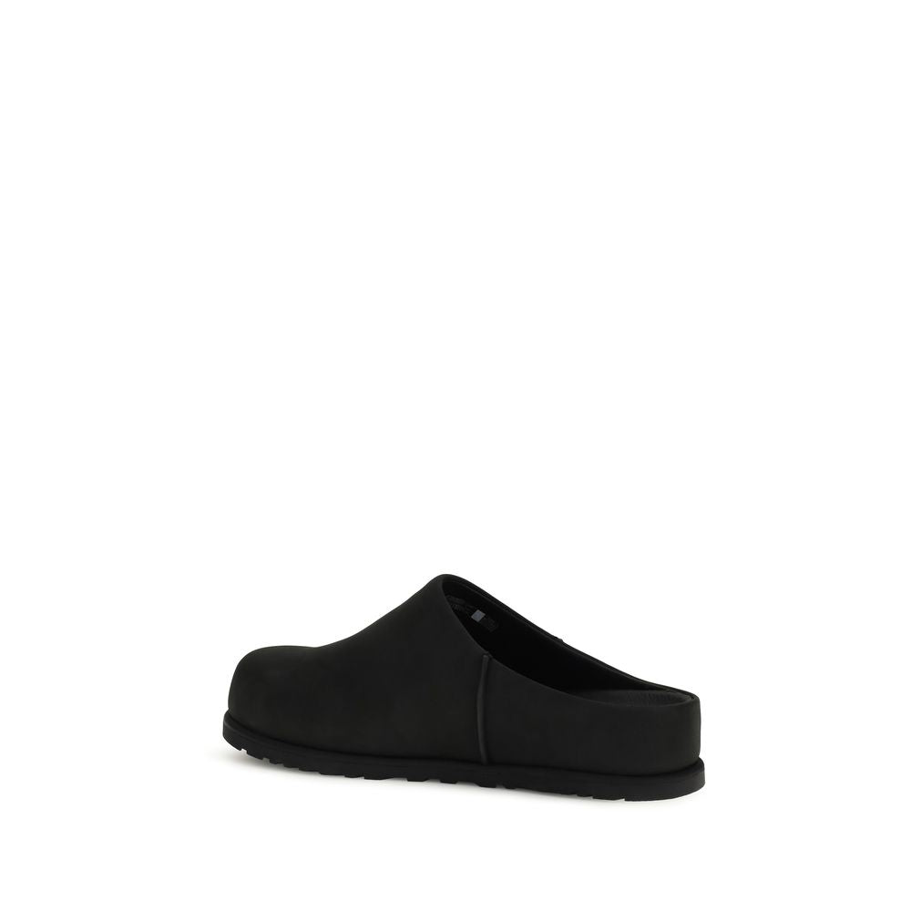 Black calf leather UGG Bos Taurus mules with slip-on design and rounded toe, showcasing a stylish and comfortable footwear option.