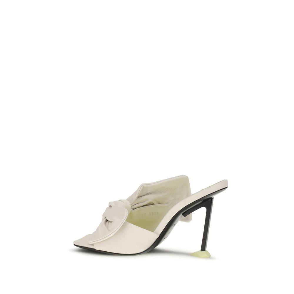 Givenchy white lamb ovis Aries mules with sleek design and pointed toes, showcasing luxury women's footwear.