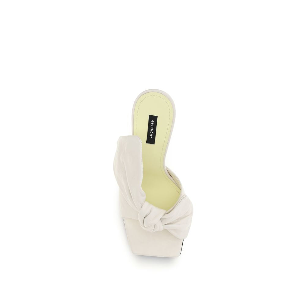 Givenchy white lamb ovis Aries mules with pointed toes and sleek design, showcasing luxury leather footwear.