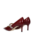 Red leather Jimmy Choo high heel pumps with pointed toes and sleek design, perfect for elegant evening wear.