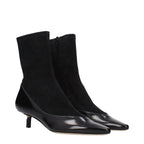 Black leather ankle boots by Jacquemus featuring sleek design and pointed toe, styled on a model.