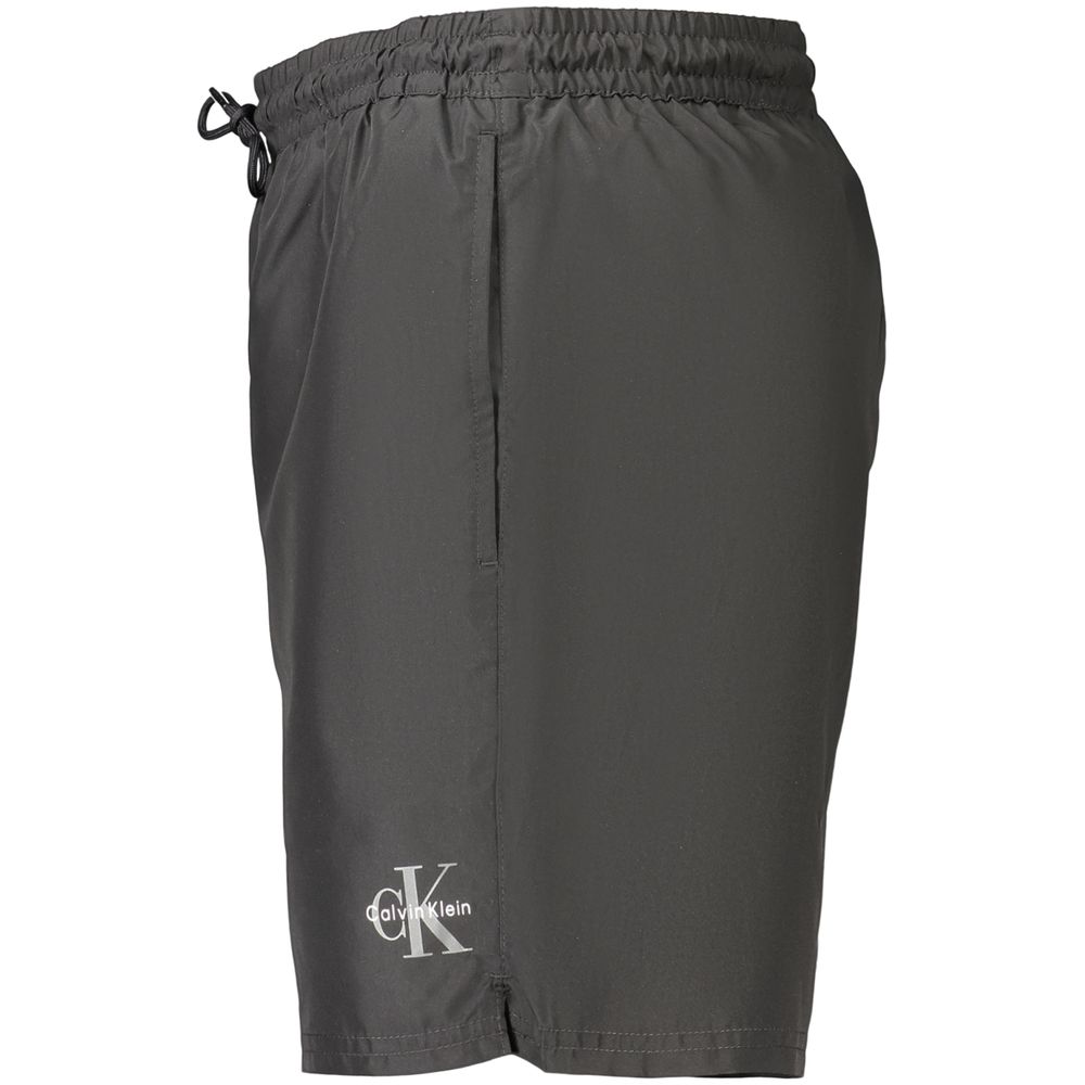 Black Calvin Klein men's polyester swimwear with a sleek design, featuring the brand logo on the waistband.