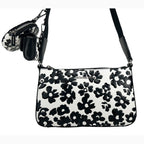 Michael Kors floral crossbody tech attachment bag with colorful floral design and adjustable strap, suitable for carrying small tech essentials.