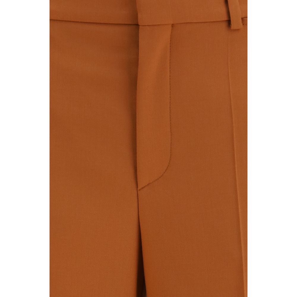 Chloé orange cotton flared pants displayed on a hanger with a high waist and wide-leg design, showcasing stylish casual fashion.
