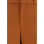 Chloé orange cotton flared pants displayed on a hanger with a high waist and wide-leg design, showcasing stylish casual fashion.