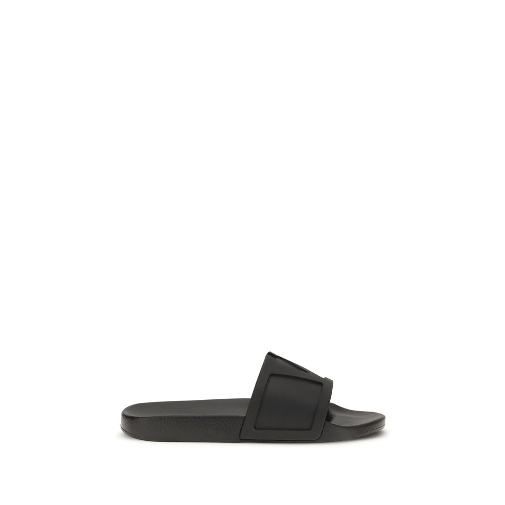Valentino Garavani black rubber flat sandals with open toe design and adjustable ankle straps.