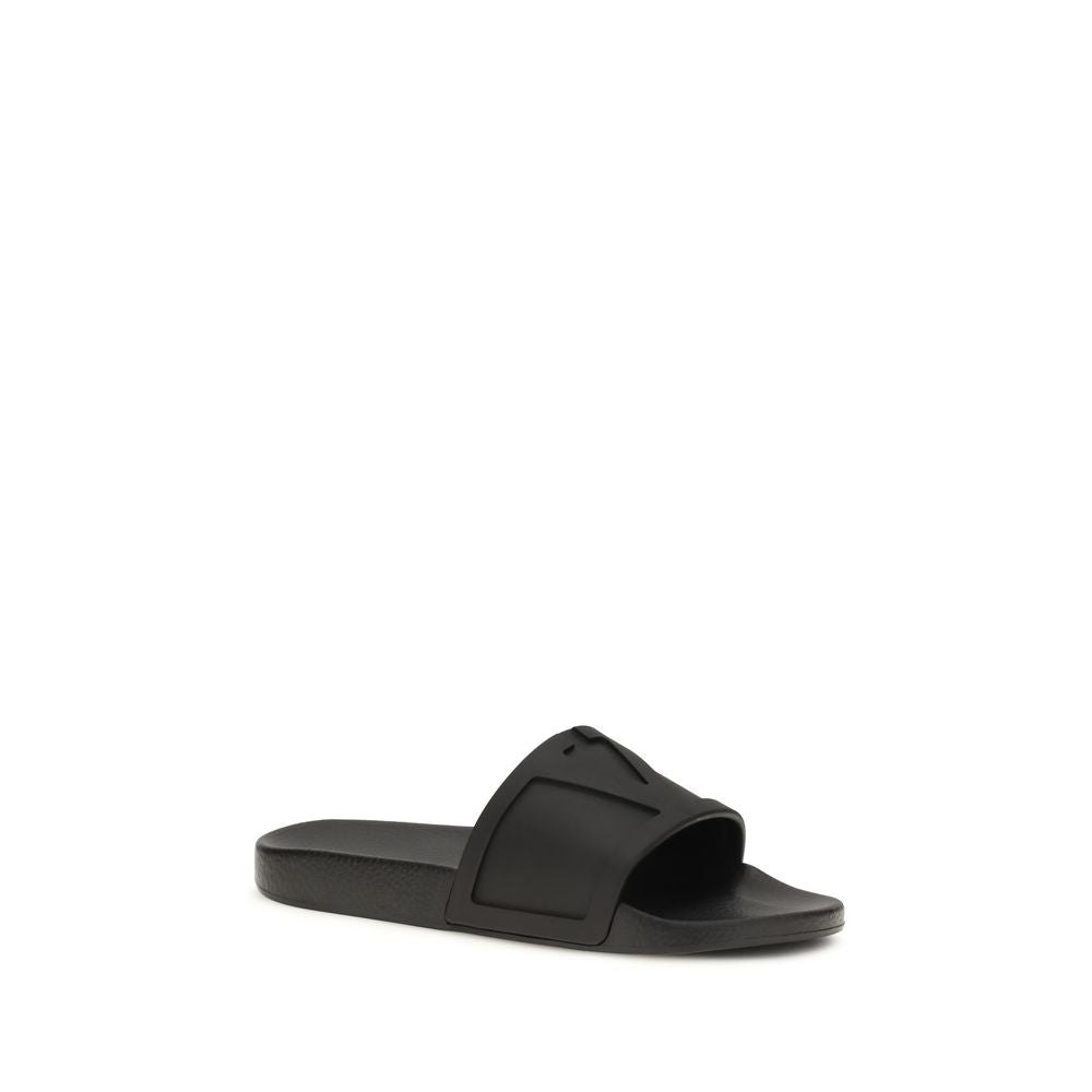 Valentino Garavani black rubber flat sandals with open toes and minimalist design, showcasing a sleek, modern style.