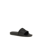 Valentino Garavani black rubber flat sandals with open toes and minimalist design, showcasing a sleek, modern style.