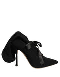 Dolce & Gabbana black stiletto heels with mid-calf length, pointed toes, and sleek leather design.