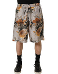 Beige floral print silk Bermuda shorts for men by Dolce & Gabbana, featuring a relaxed fit and elegant floral design.