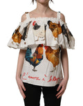 Dolce & Gabbana white rooster print off-the-shoulder poplin top with long sleeves and feminine fit.