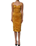 Dolce & Gabbana gold silk ruched bodycon midi dress displayed on a mannequin, highlighting its elegant design and fitted silhouette.