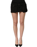 Black cotton Dolce & Gabbana mid-waist A-line mini skirt displayed on a hanger, showcasing its sleek design and tailored fit.