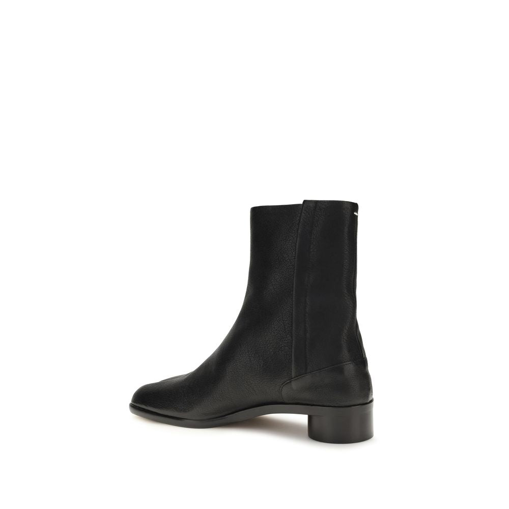 Maison Margiela black calf leather Bos Taurus ankle boots with sleek design and pointed toe, displayed on a neutral background.