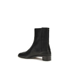 Maison Margiela black calf leather Bos Taurus ankle boots with sleek design and pointed toe, displayed on a neutral background.