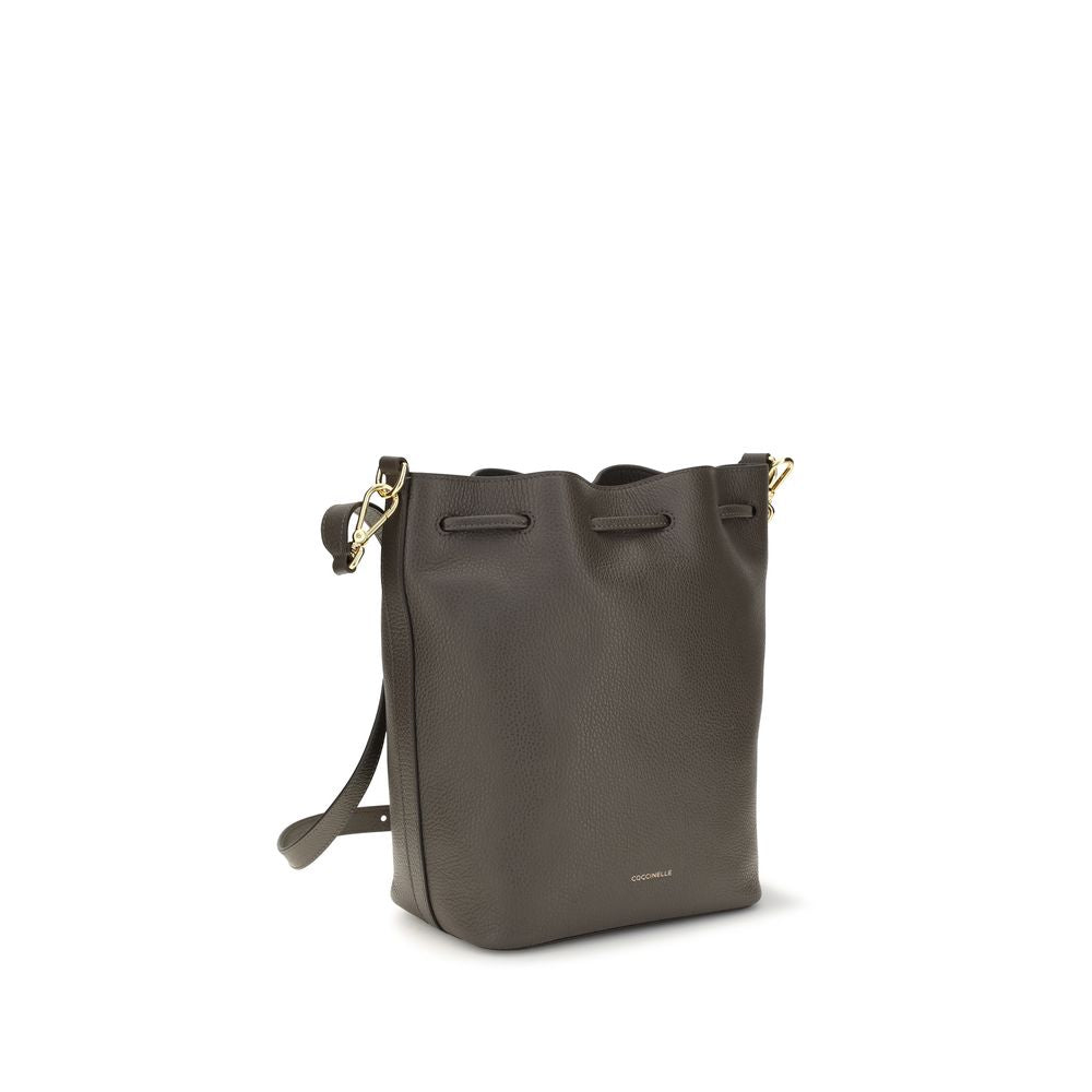 Coccinelle brown calf leather Bos Taurus backpack bag with top handles and adjustable shoulder strap on a plain background.