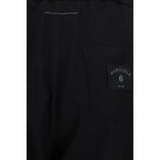 Black polyester casual pants by MM6, featuring a relaxed fit and minimalist design, displayed on a neutral background.