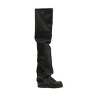 Black polyurethane over-the-knee boots by The Attico with sleek design and pointed toe, displayed on a model.