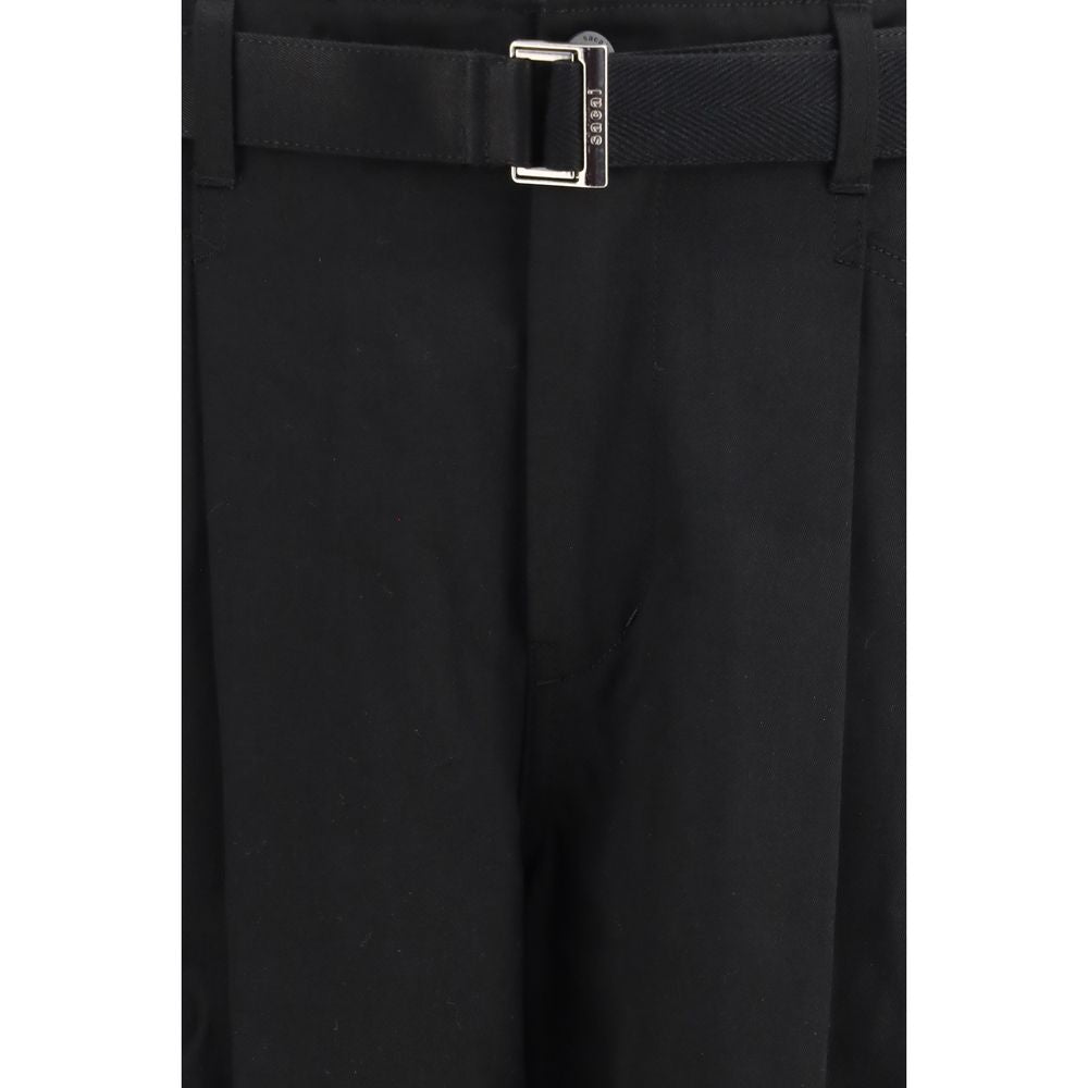 Sacai black cotton chino pants with a slim fit, front pockets, and belt loops, displayed on a neutral background.