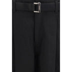 Sacai black cotton chino pants with a slim fit, front pockets, and belt loops, displayed on a neutral background.