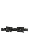 Black floral silk bow tie with adjustable neck strap by Dolce & Gabbana, designed for men's formal wear.