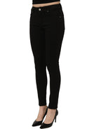 Black cotton stretch skinny denim jeans by Dolce & Gabbana displayed on a hanger with a modern background.