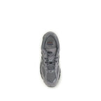 Gray fabric New Balance athletic sneakers with white soles, featuring breathable material and sporty design for active wear.