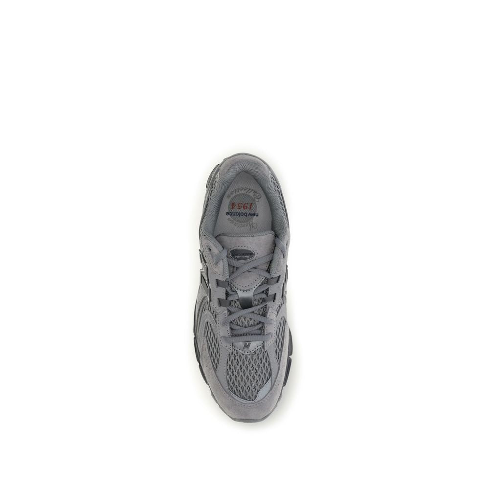 Gray fabric New Balance athletic sneakers with white soles, featuring breathable material and sporty design for active wear.