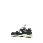 Blue suede leather athletic sneakers by New Balance, featuring sporty design and white rubber soles.