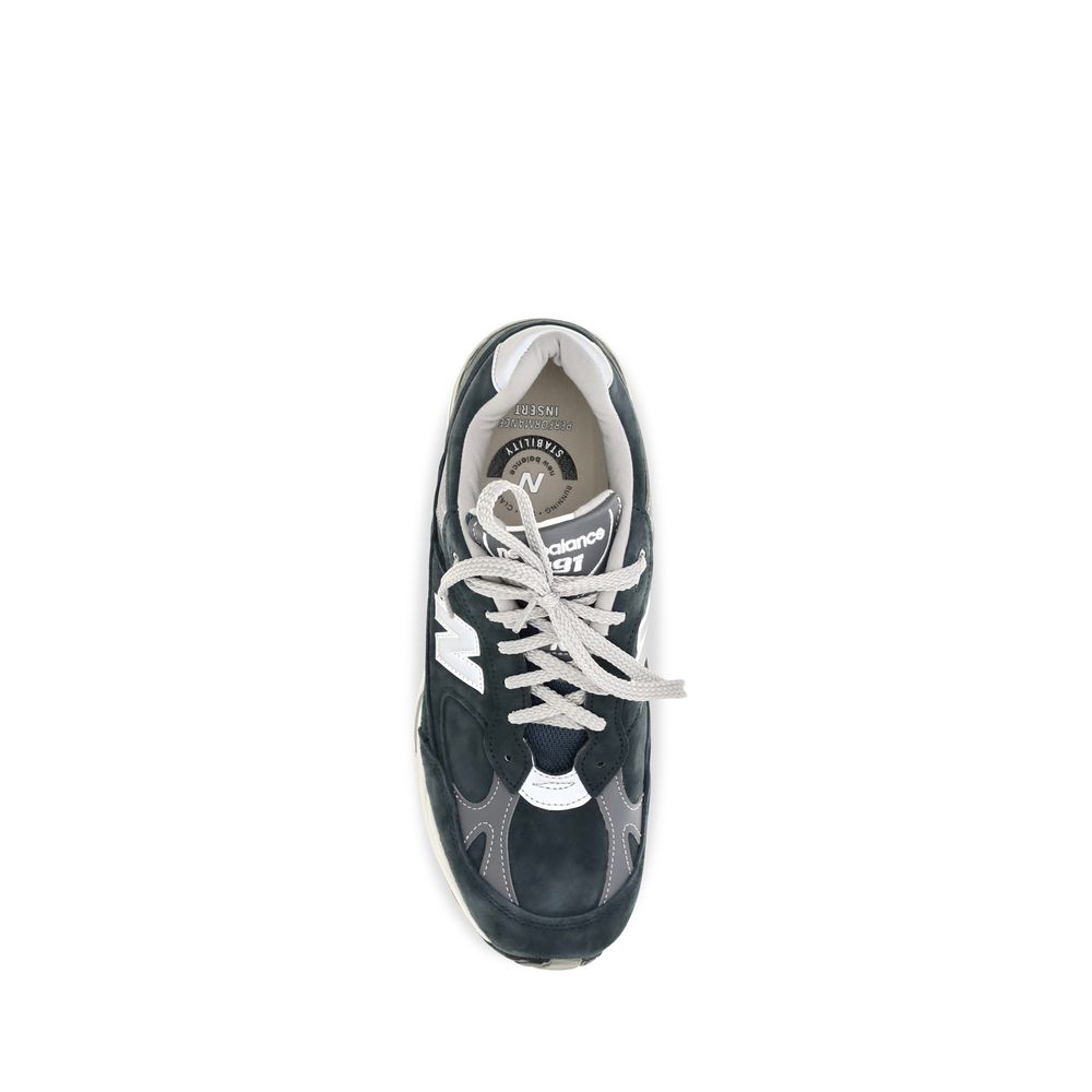 Blue suede leather athletic sneakers by New Balance, featuring a sporty design with white rubber soles and lacing.