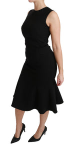 Dolce & Gabbana black fit-and-flare wool stretch sheath dress displayed on a hanger with a smooth background.