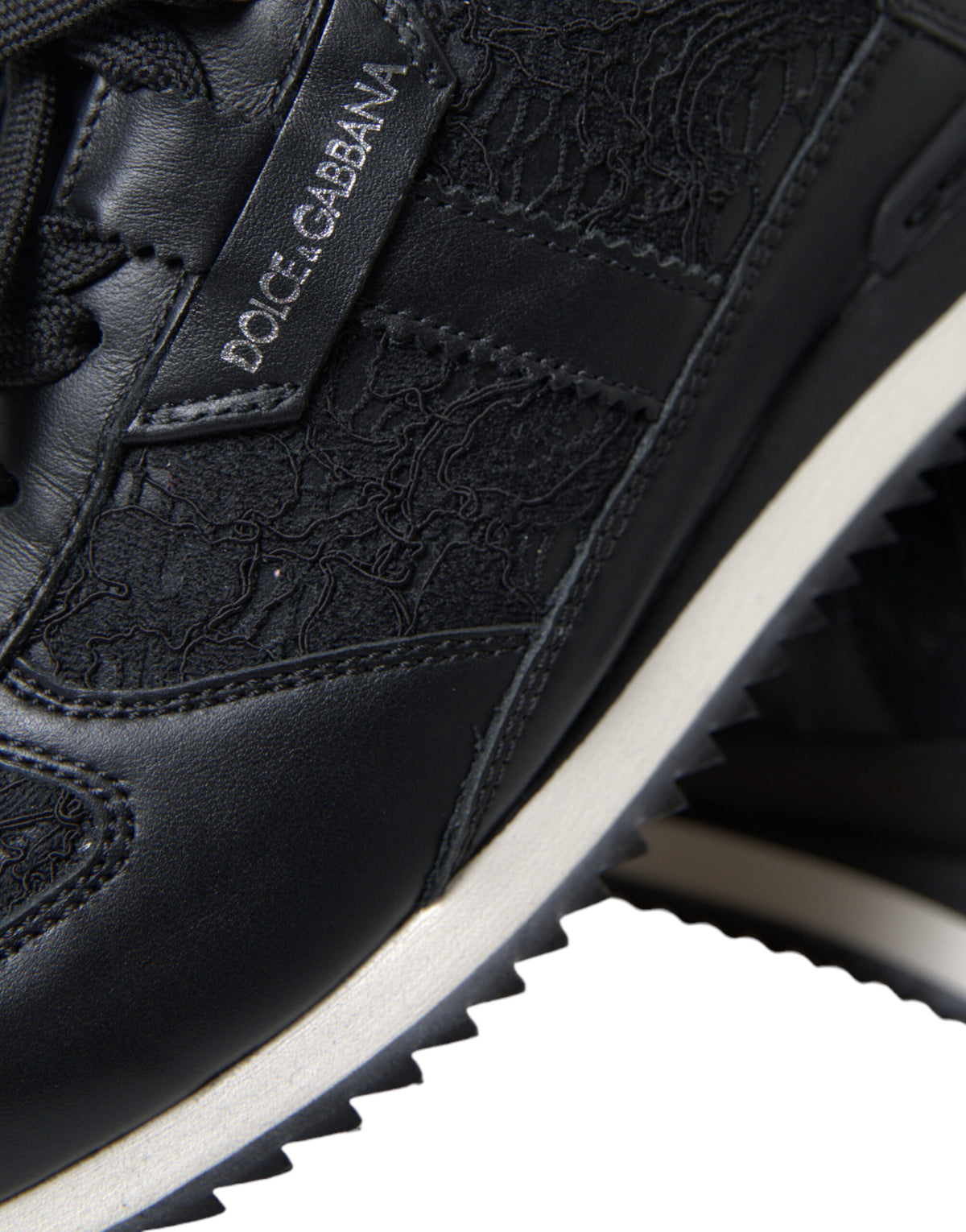 Dolce & Gabbana black floral lace leather sneakers showing detailed floral lace design and sleek leather construction.