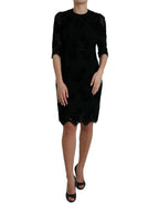 Black floral lace cotton Dolce & Gabbana bodycon dress displayed on a hanger with intricate lace details and fitted silhouette.