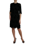 Dolce & Gabbana black floral lace cotton bodycon dress displayed on a mannequin, showcasing elegant floral lace details and fitted silhouette.