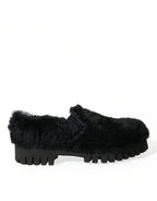 Black leather slippers with plush fur trim by Dolce & Gabbana, designed as elegant dress shoes with sleek, stylish detailing.