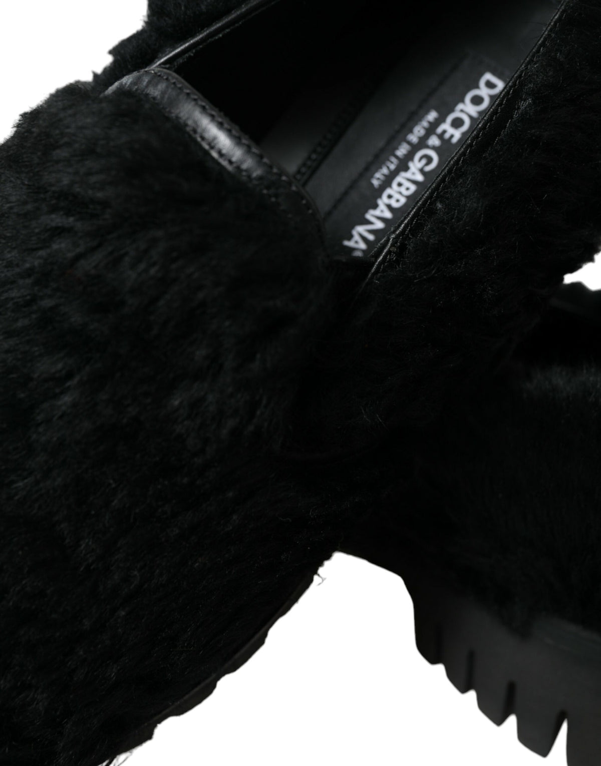 Dolce & Gabbana black fur leather slippers dress shoes with sleek design and luxurious fur trim on a plain background.