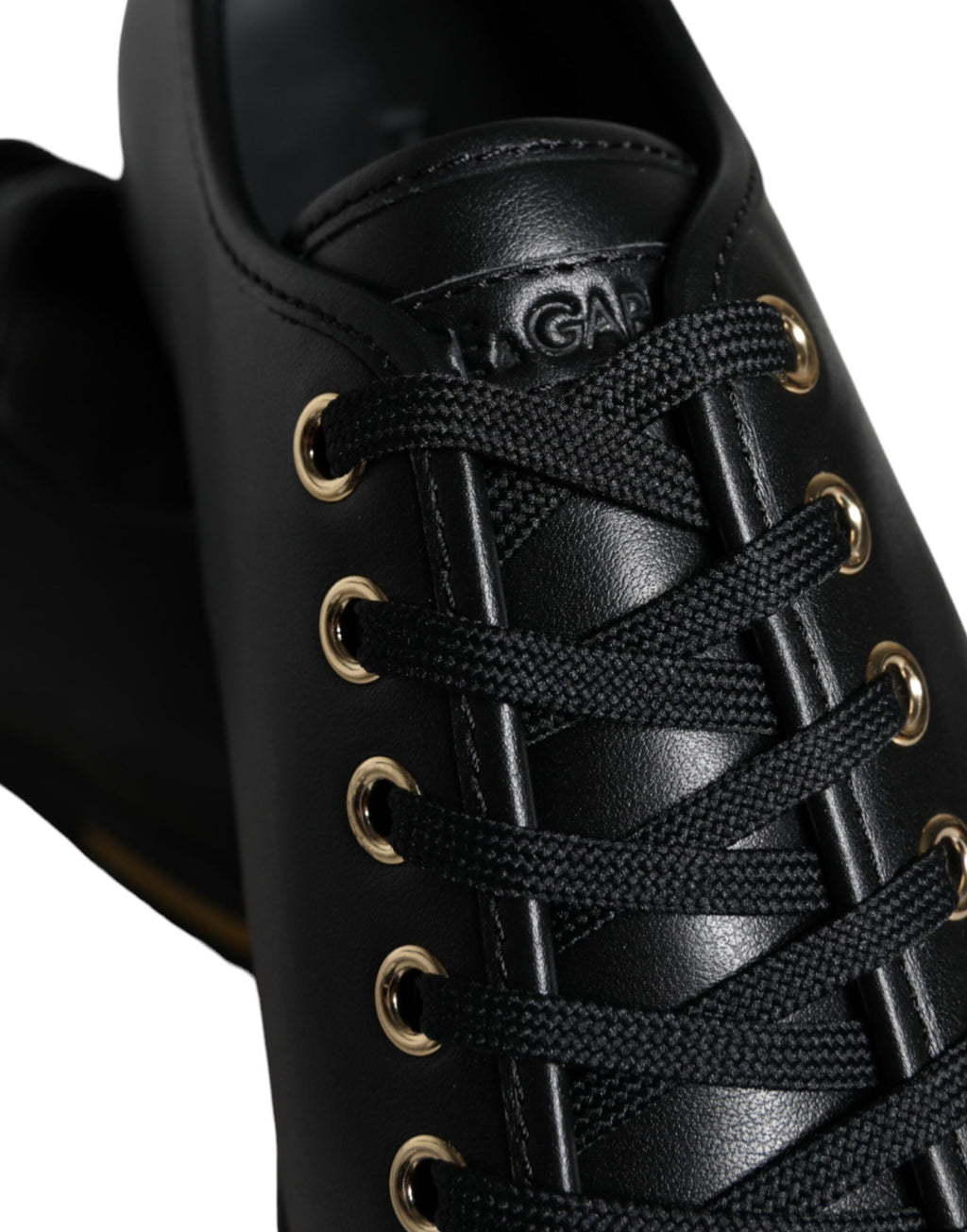 Dolce & Gabbana black leather sneakers with gold accents, classic design, and stylish laces, perfect for casual wear.