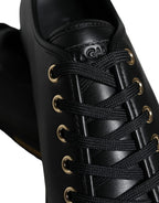 Dolce & Gabbana black leather sneakers with gold accents, classic design, and stylish laces, perfect for casual wear.
