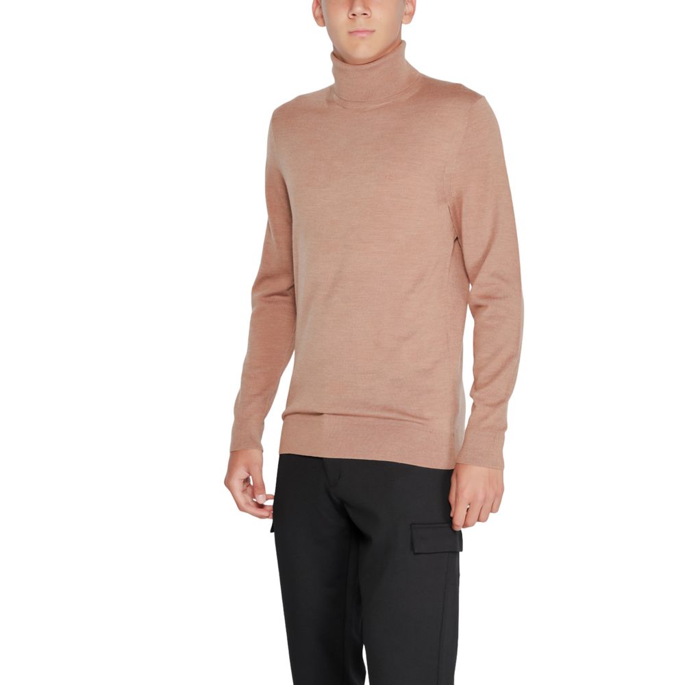 Beige wool turtleneck sweater by Calvin Klein, featuring a high neckline and classic fit, suitable for cold weather.