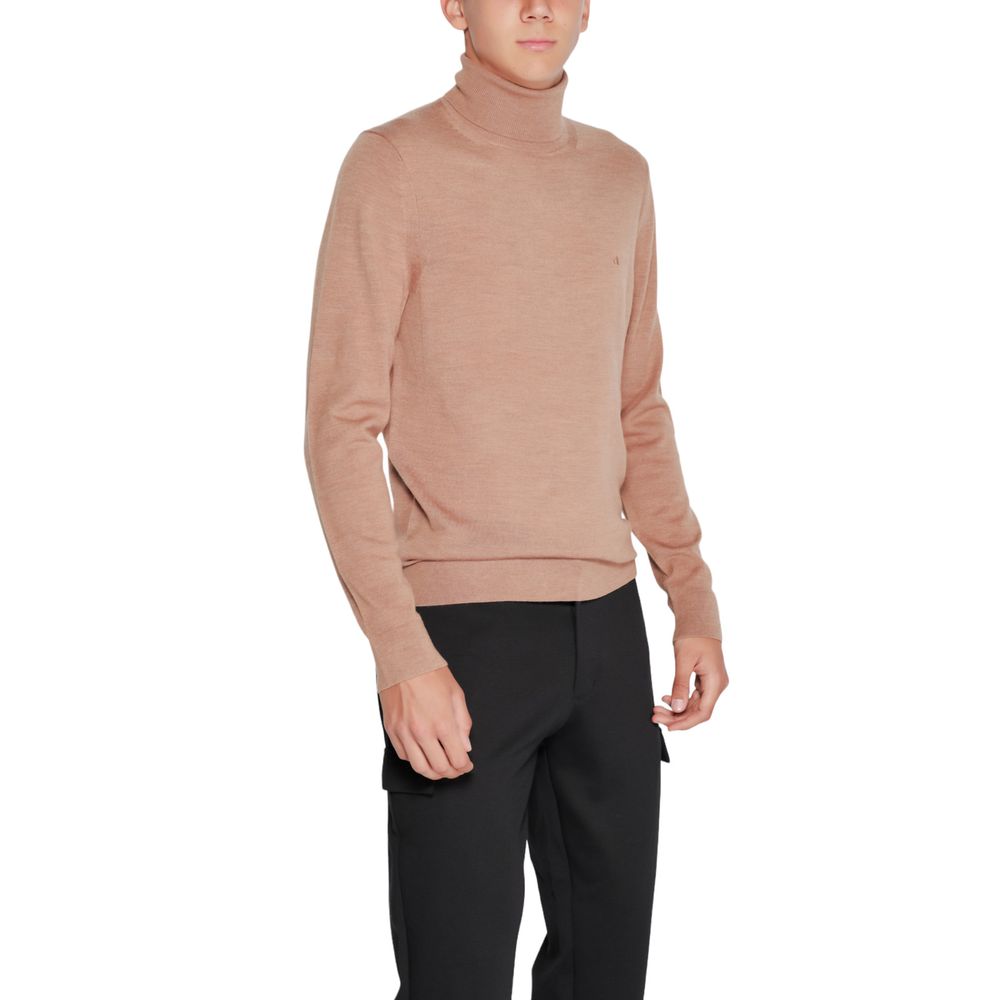 Calvin Klein beige wool turtleneck sweater displayed on a hanger, highlighting soft knit fabric and classic turtleneck design.